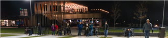 Groups of people playing Pub Curling in front of Three One Six Bar and Grill at night