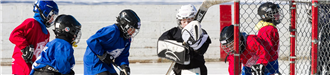 Group of young kids playing ice hockey.