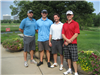 Several Golfers Stand Beside Flower Planters