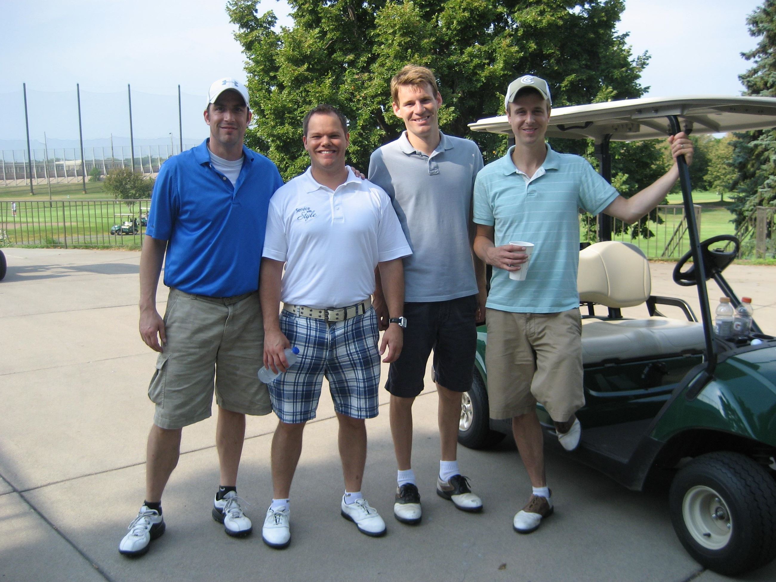 Four Golfers Beside a Golf Cart