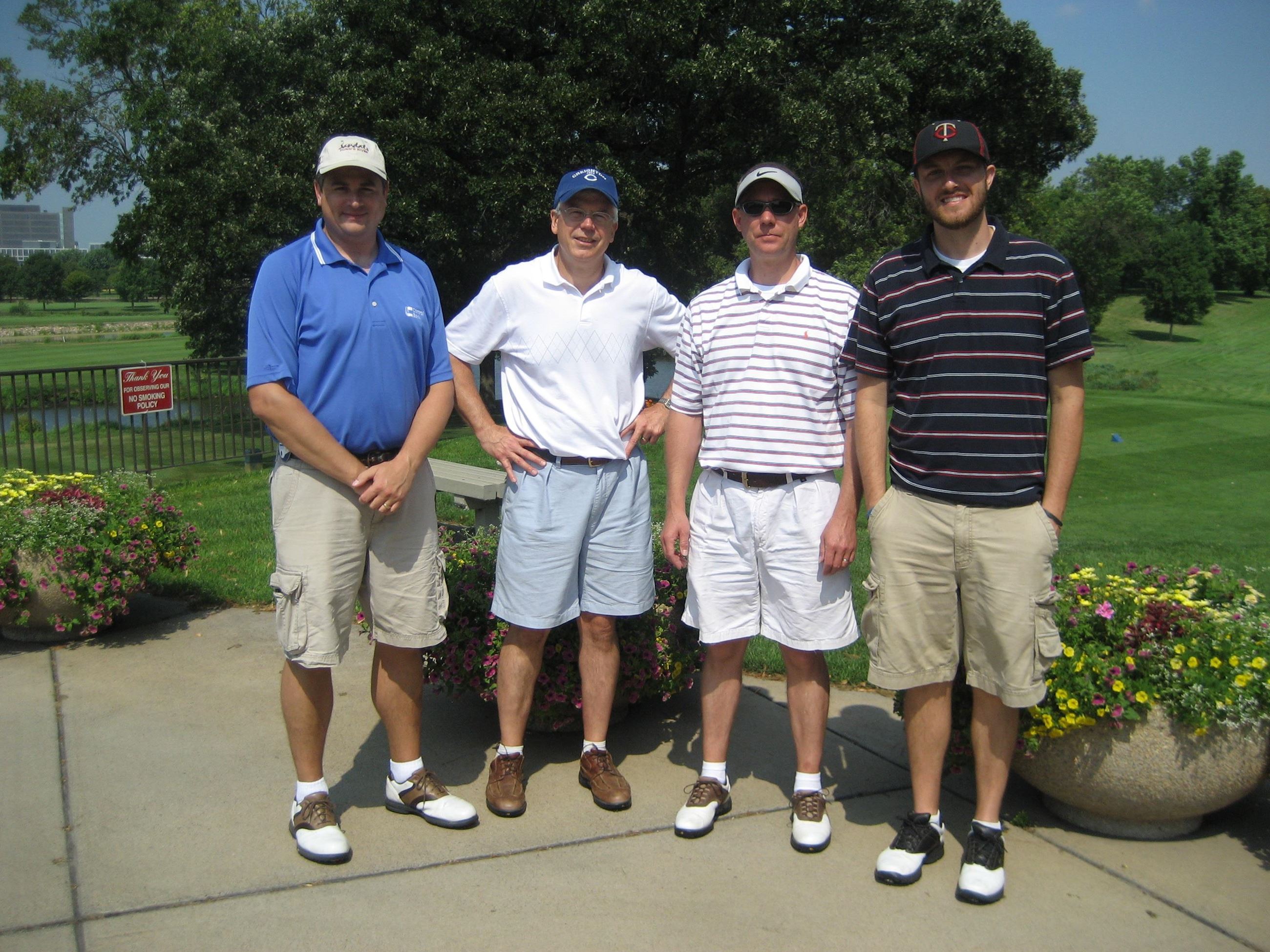 Four Golfers Pose Beside Planters