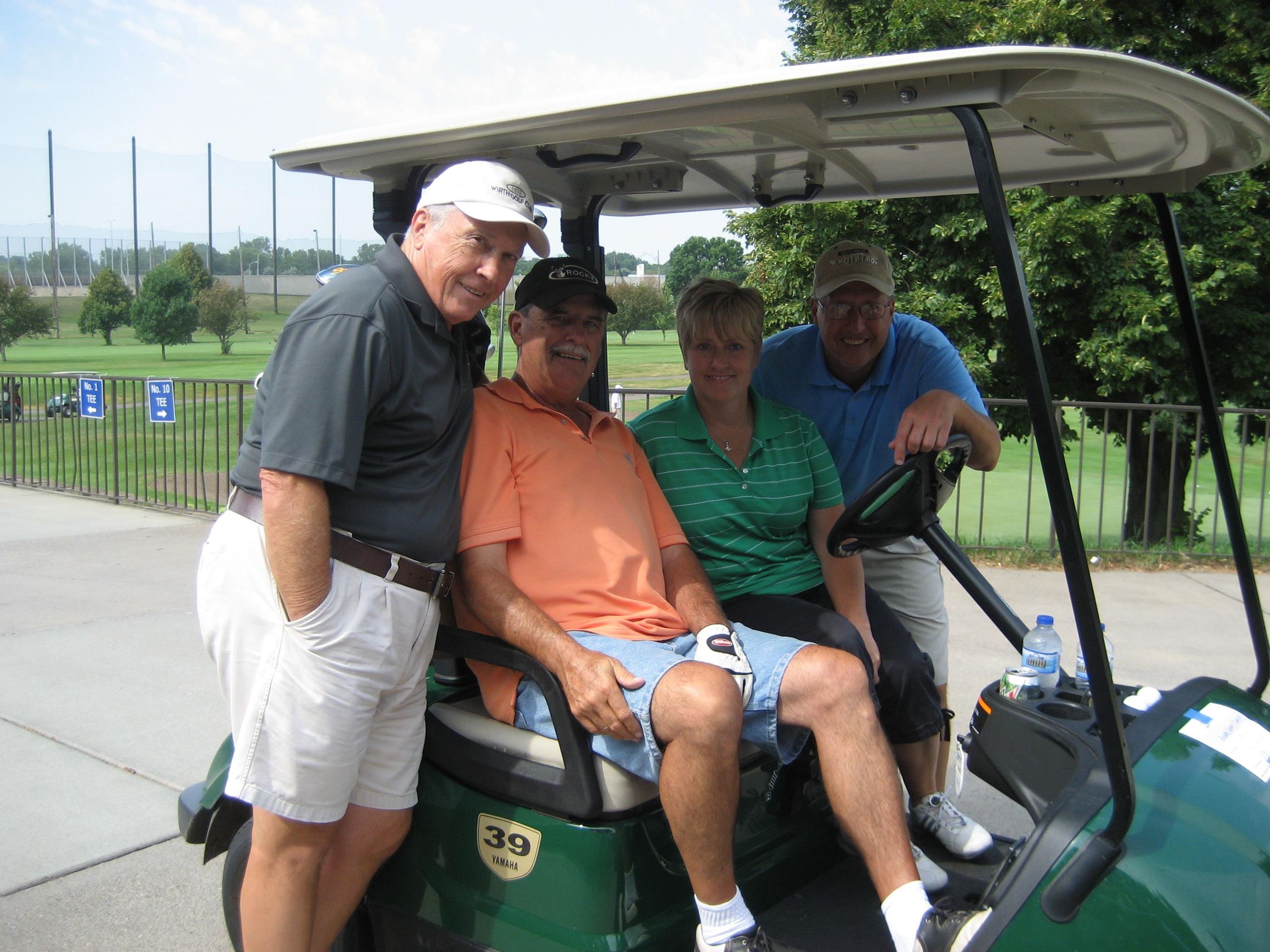 Four Golfers Take a Picture in Their Golf Cart
